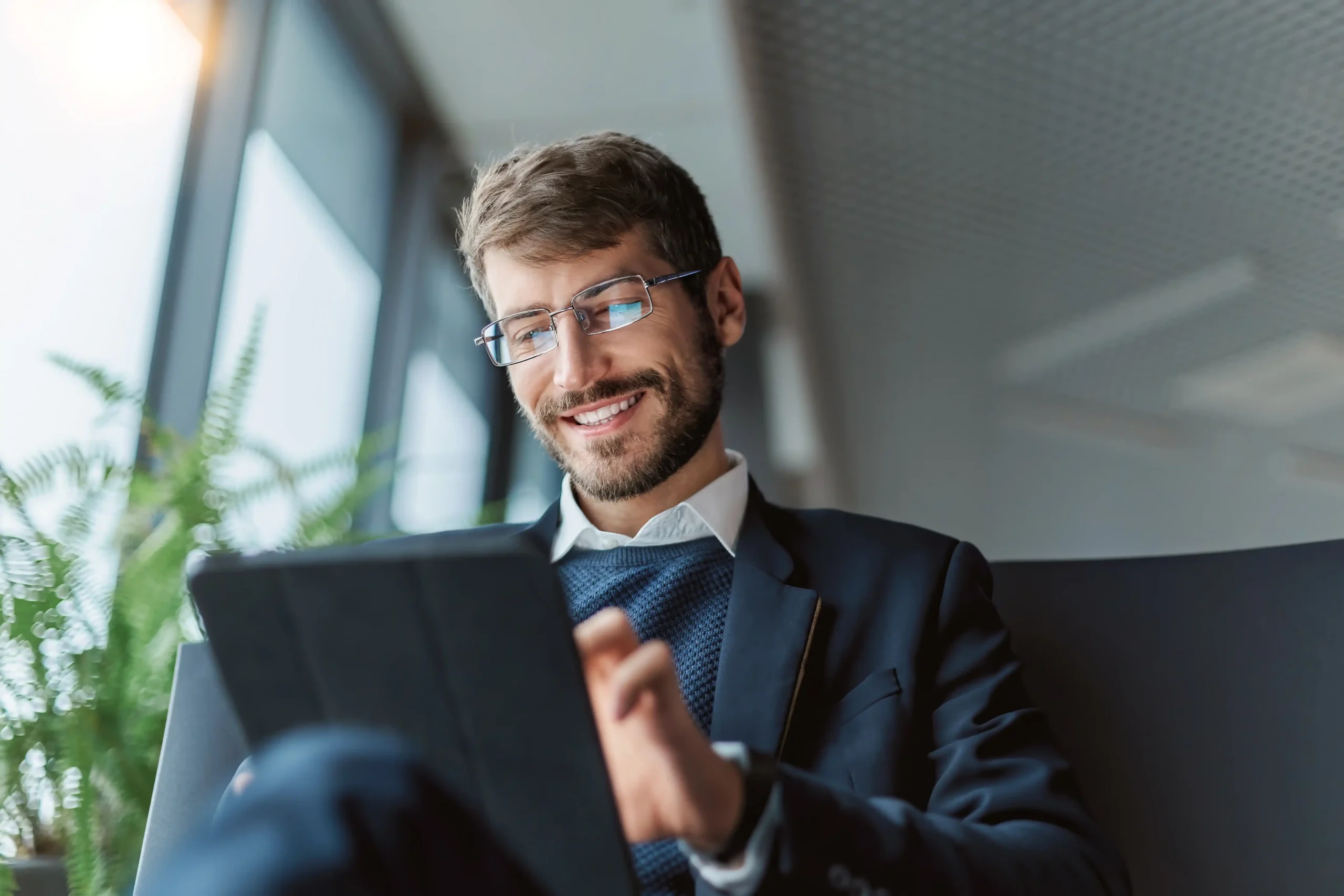 Image of a man searching how to switch business energy suppliers on a smart tablet.