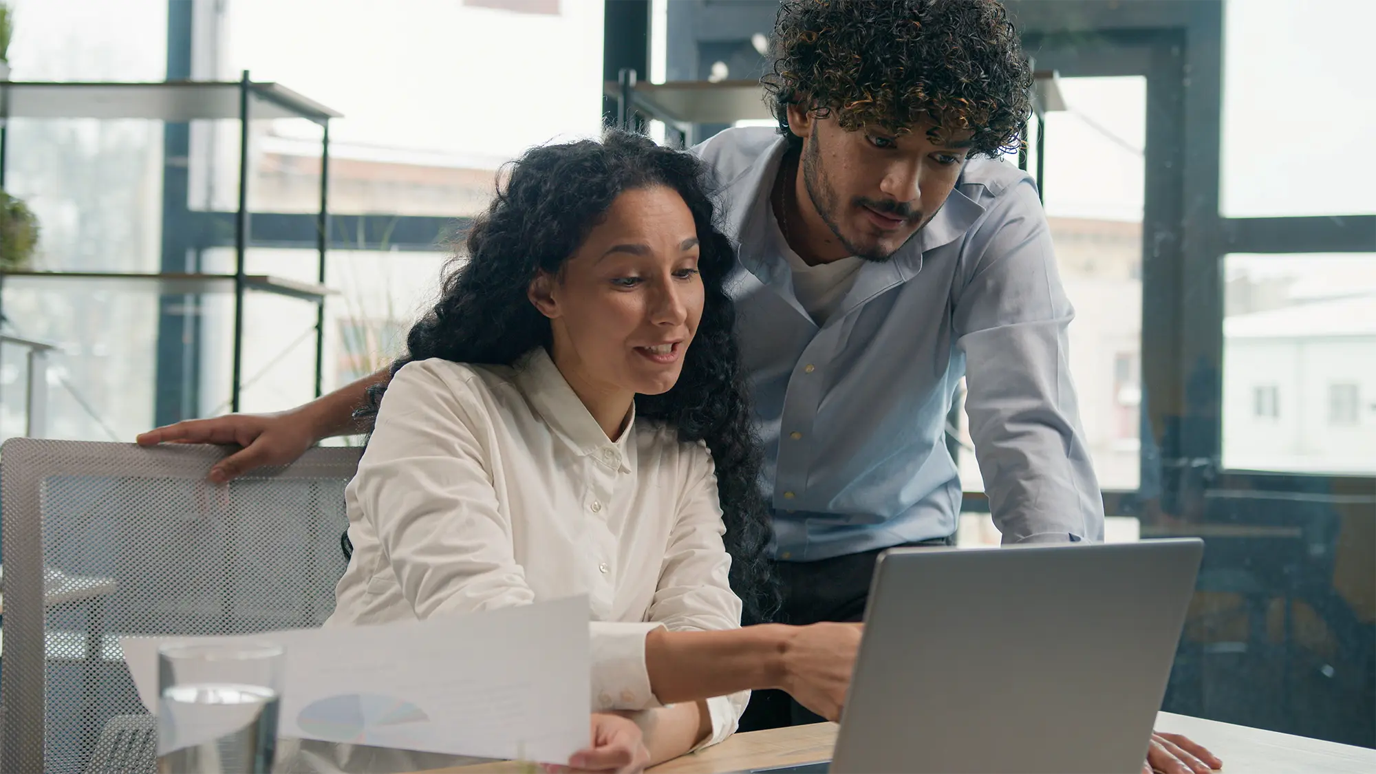 A man & women on a laptop, looking at ways they can reduce energy consumption in their business.